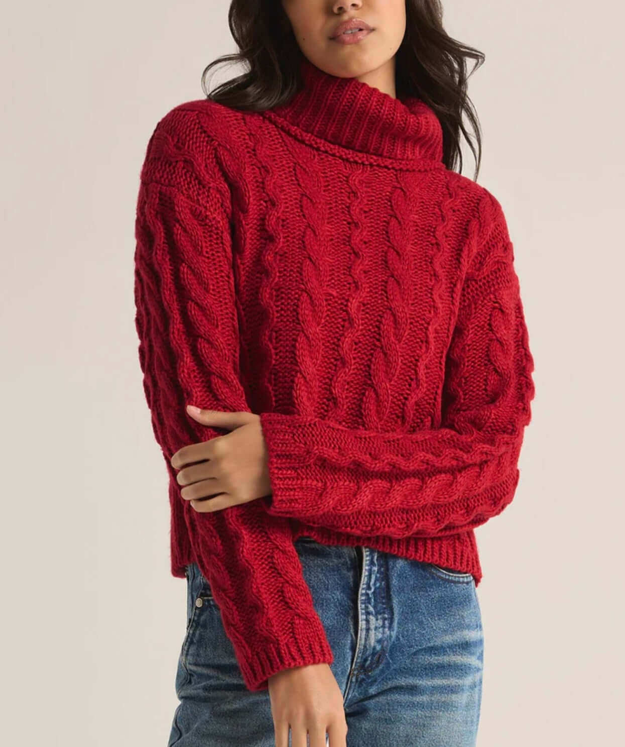 Red cable knit turtleneck sweater showcased with casual denim, perfect for stylish winter outfits.