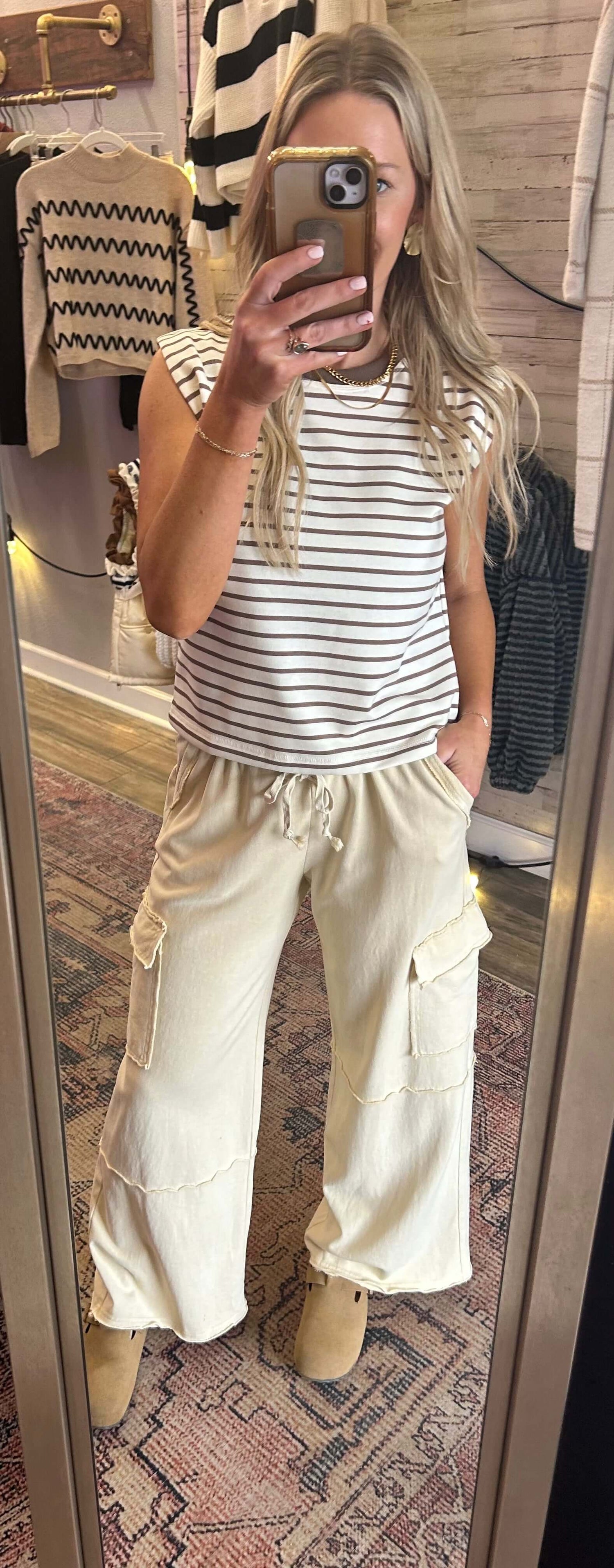 Stylish woman wearing a striped top and cream cargo pants, reflecting casual fashion trends.