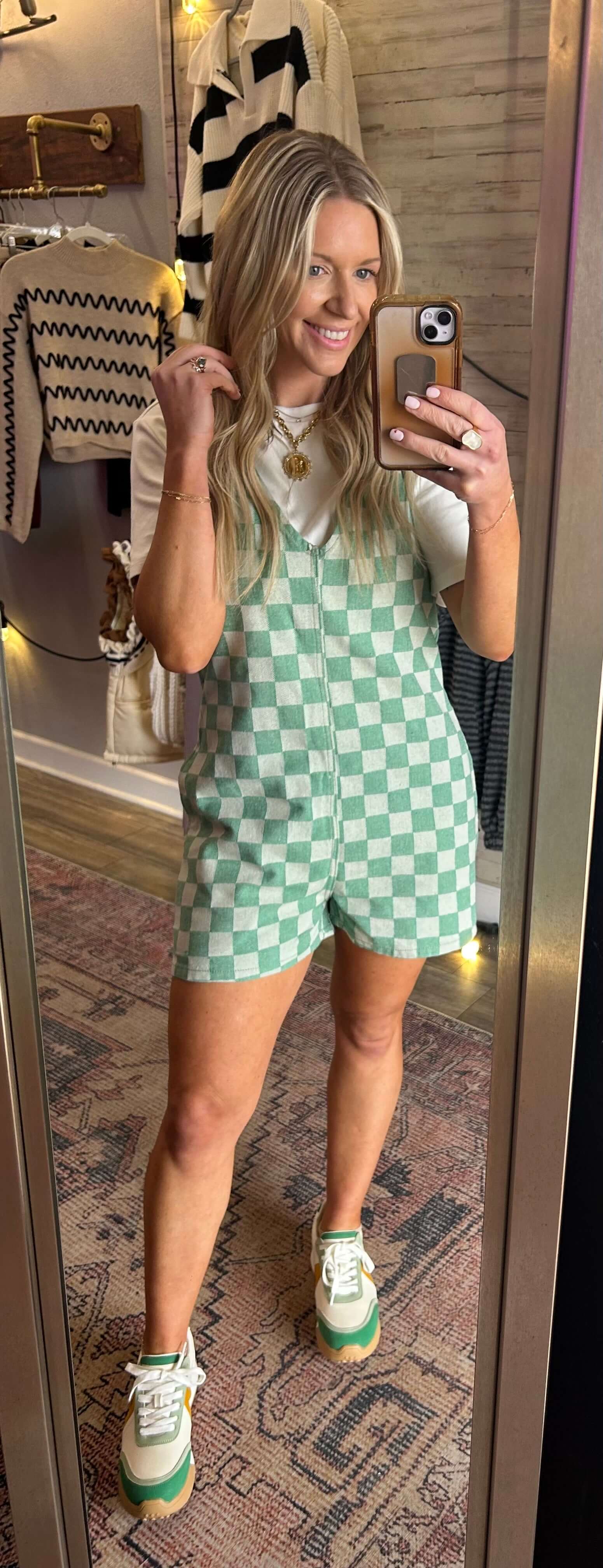 Model wearing a checkered evergreen romper with V neck and side zip closure, perfect for summer fashion.