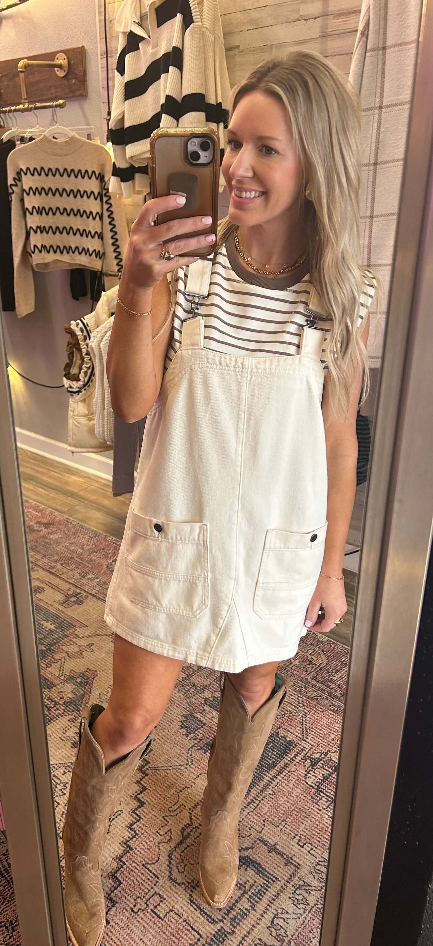 Model wearing a washed bone denim overall dress with adjustable straps, styled for summer concerts and vacations.