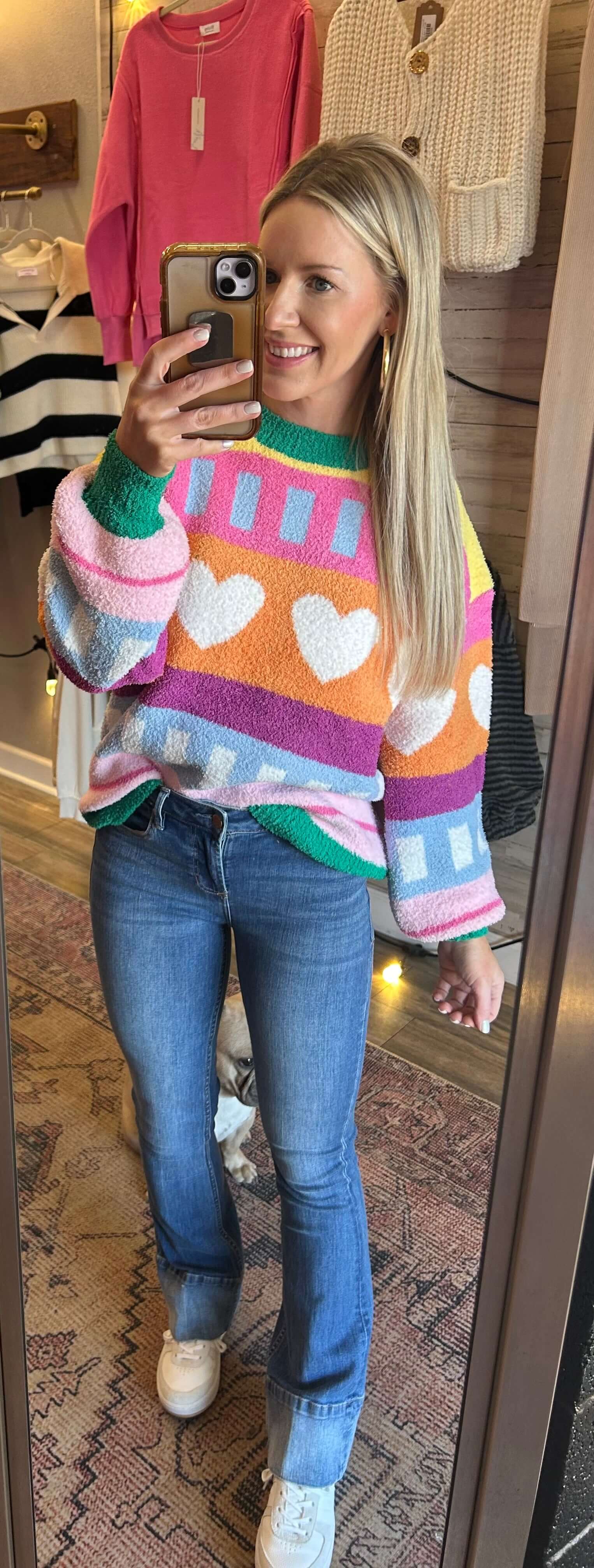 Woman wearing a colorful patterned hearts soft knit sweater, perfect for winter and Valentine's Day.