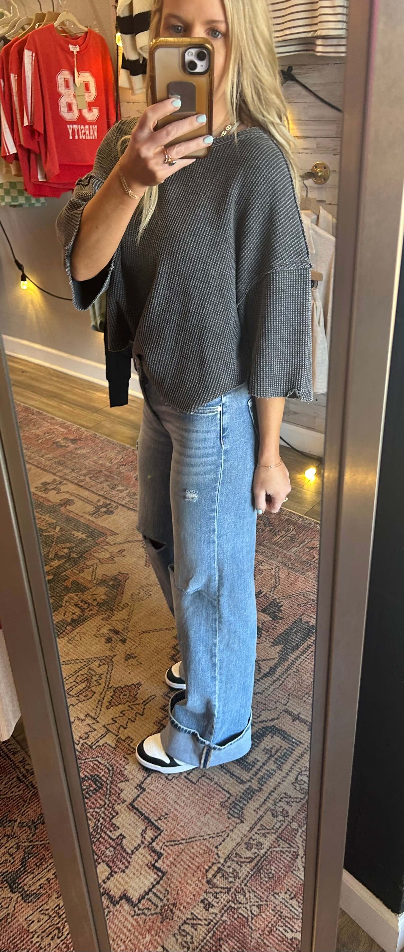 Model wearing Risen MidRise Wide Leg Cuffed Jeans with medium wash and knee slit, paired with a gray top.