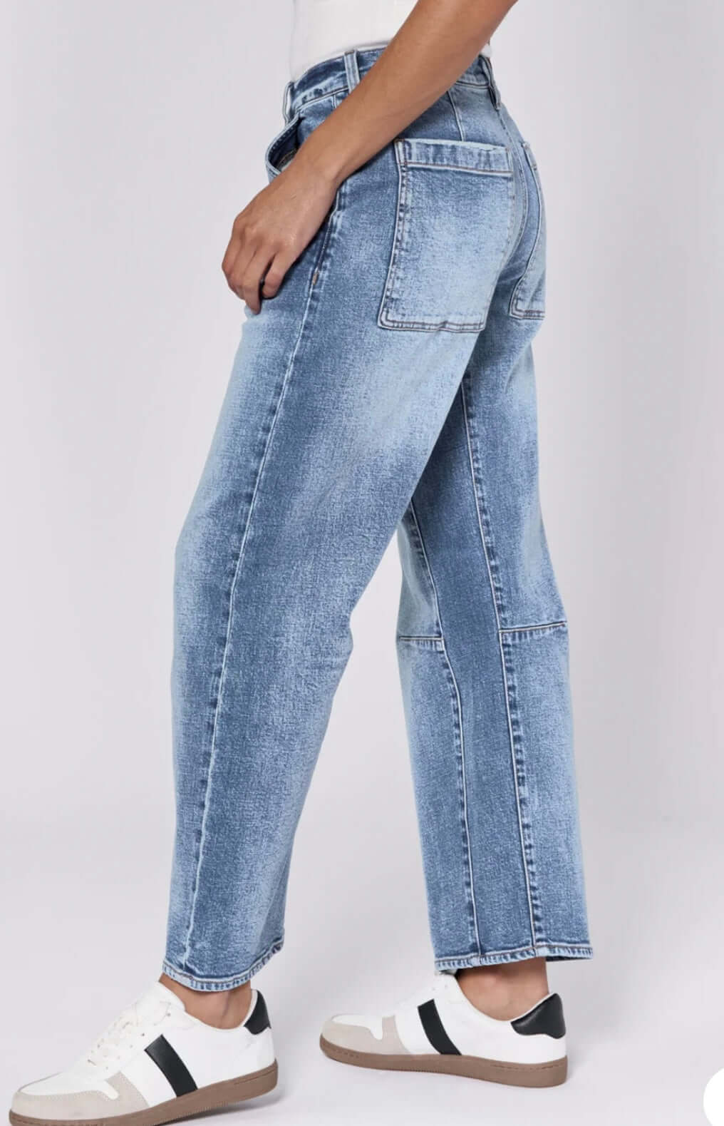 Model showcasing Dear John Lasso highrise cropped barrel jeans in medium wash, styled with casual sneakers.