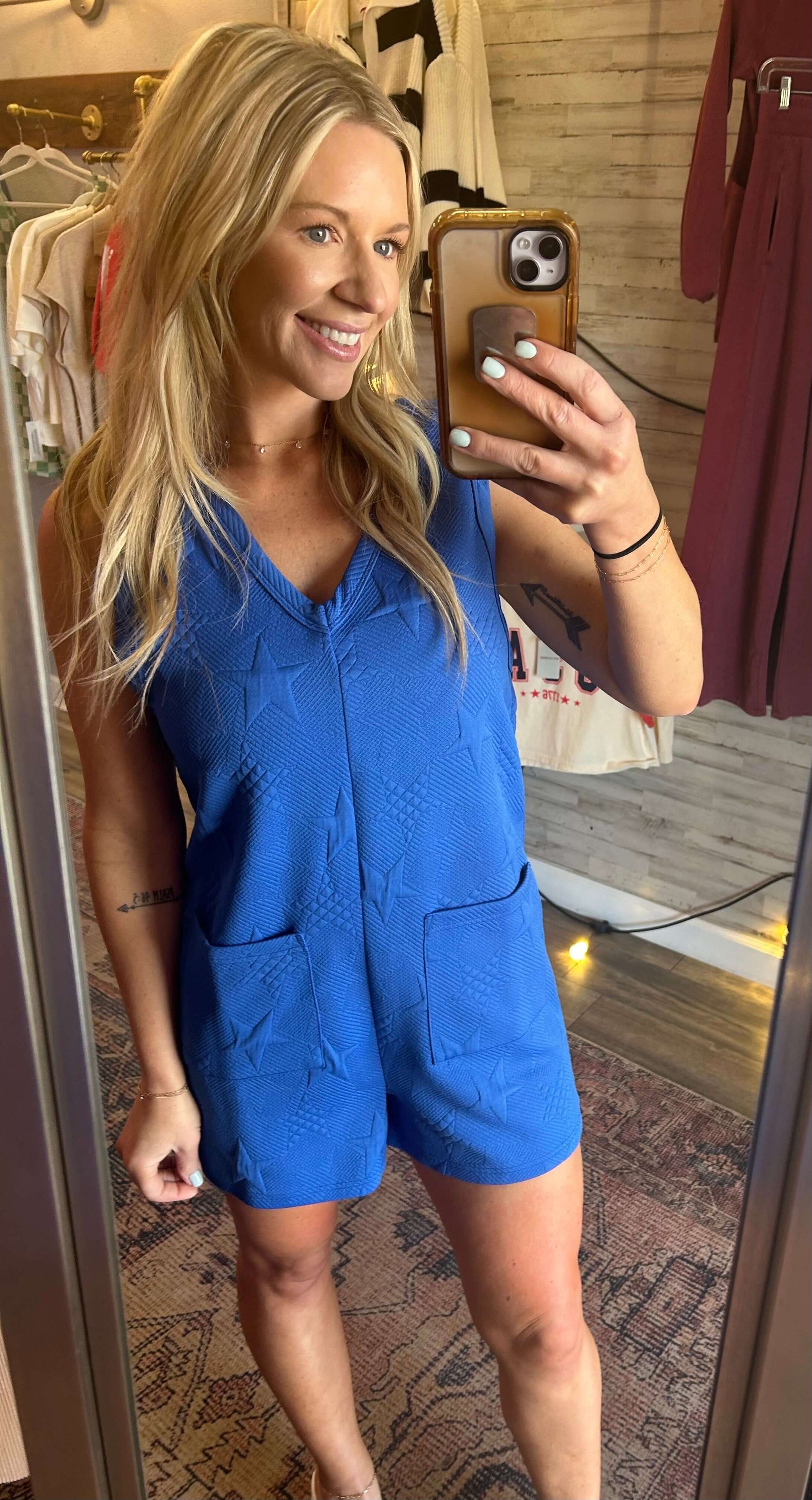 Model wearing a royal blue star textured V neck romper with pockets, perfect for Spring Break and summer events.
