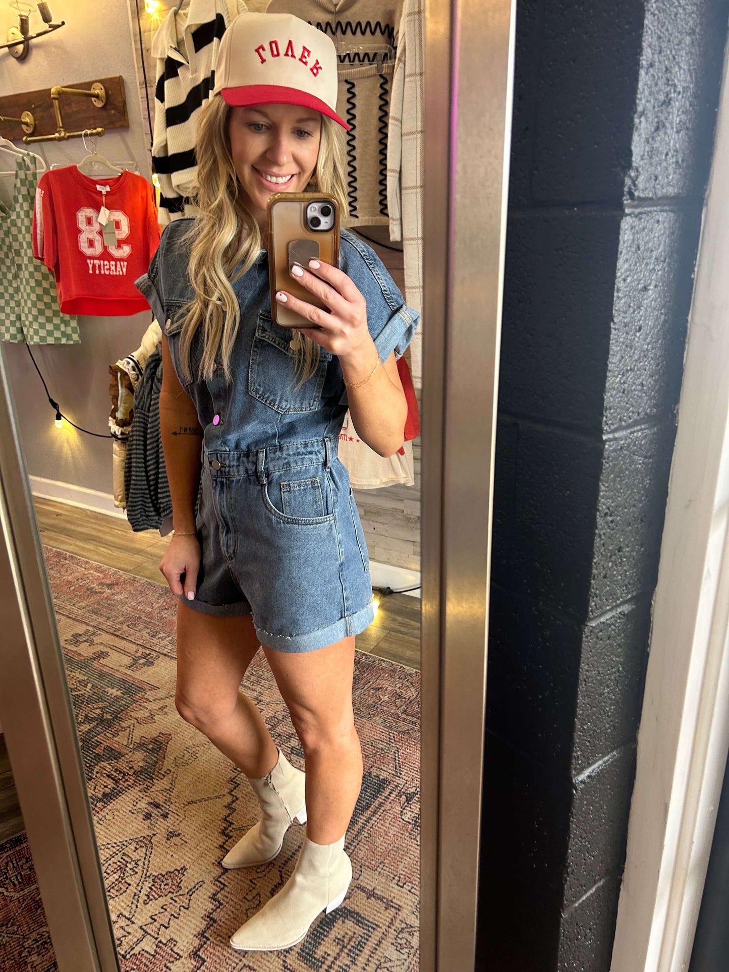 Denim Days Button Down Romper featuring cuff hem, flattering elastic back and zipper fly in a stylish mirror selfie.