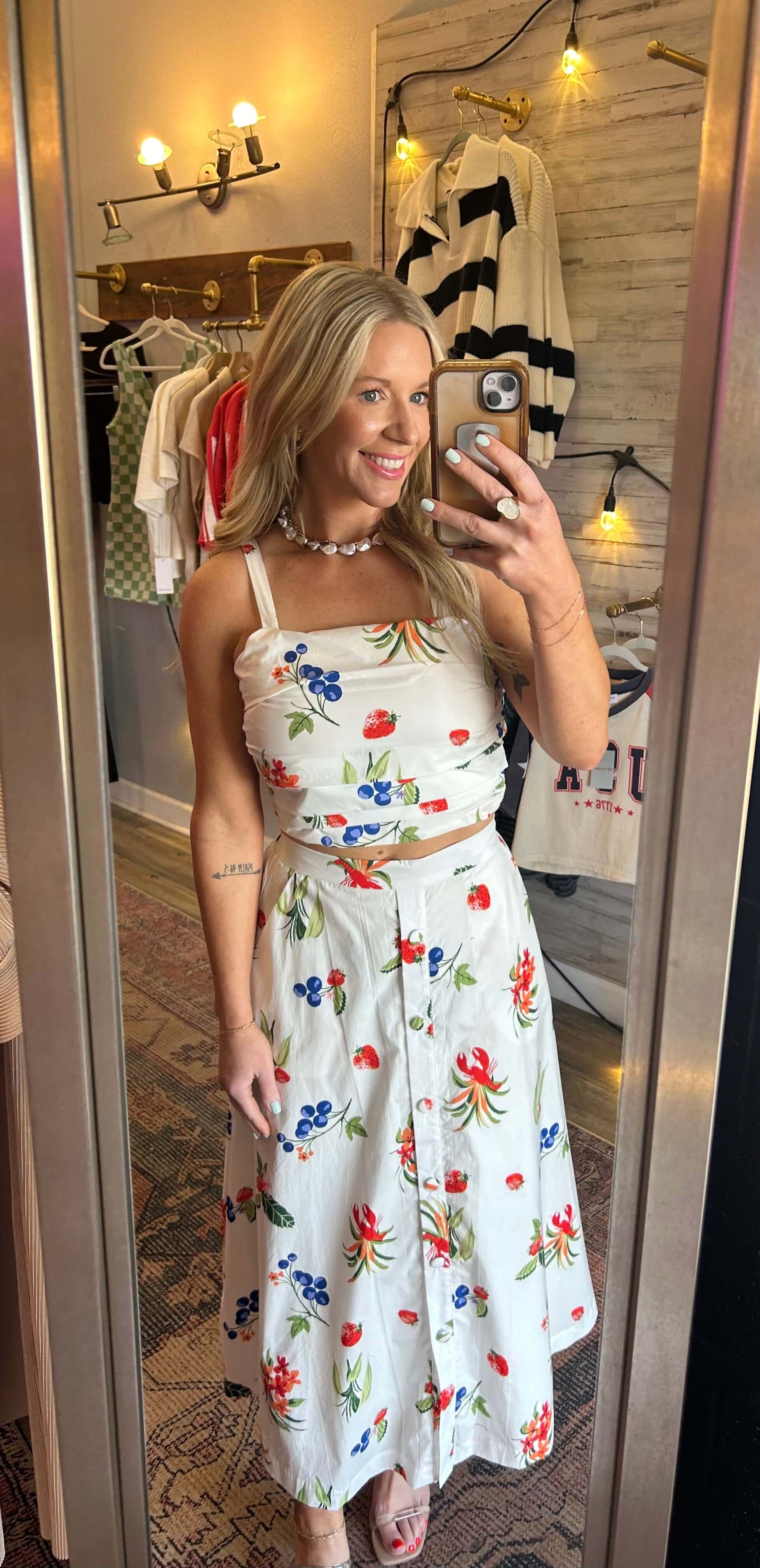 Smiling woman in a colorful floral 2pc skirt set with adjustable straps and an elastic waist, perfect for summer.