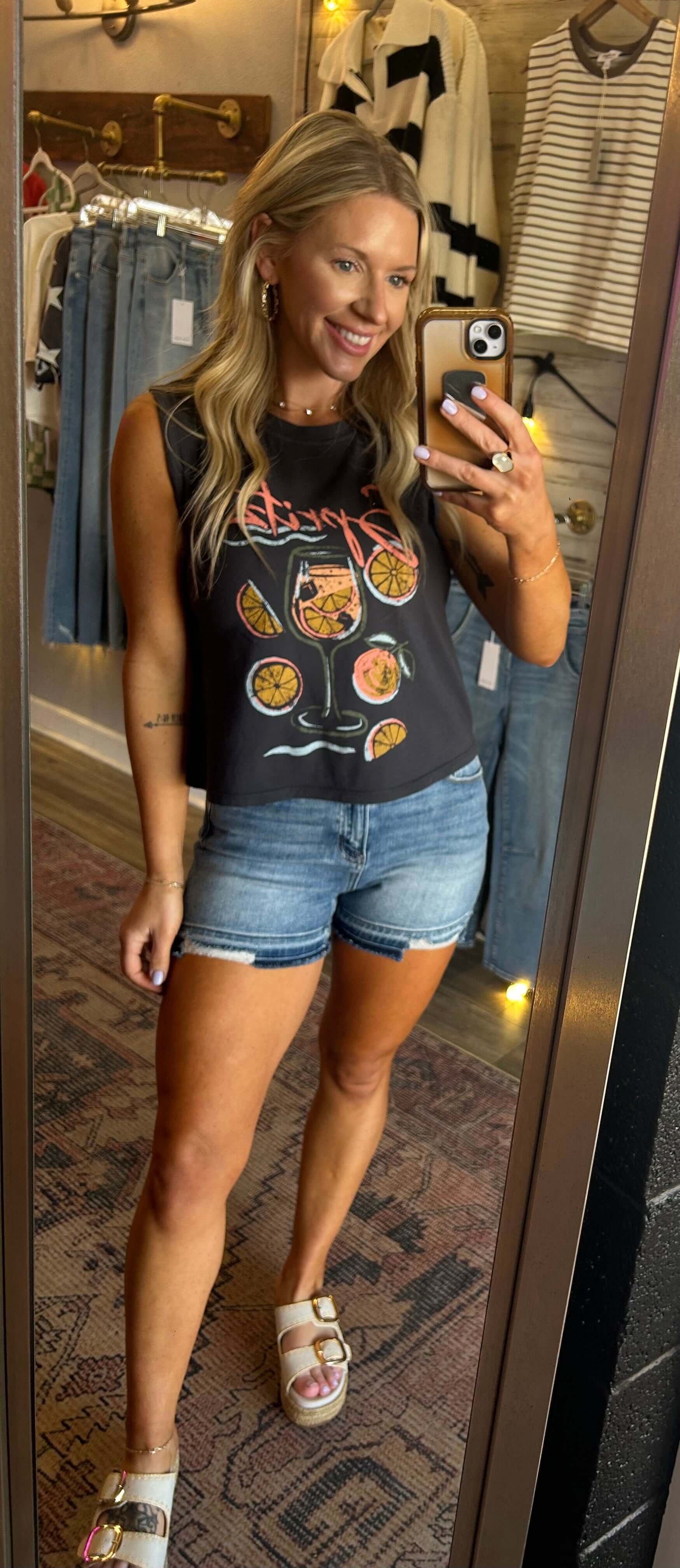 Model wearing Z Supply Spritz La Mar Tank with citrus graphic, paired with denim shorts in a stylish boutique setting.