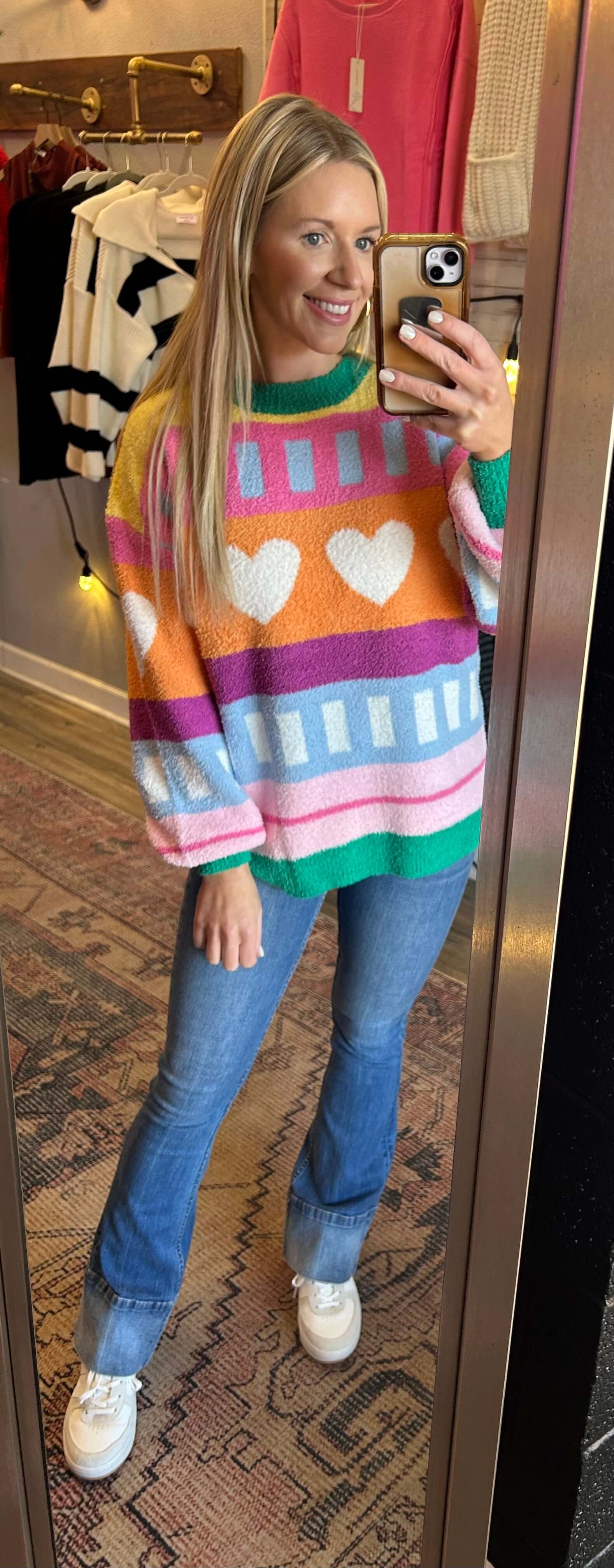 Model wearing a colorful, soft knit sweater with heart patterns, ideal for winter and Valentine's Day.
