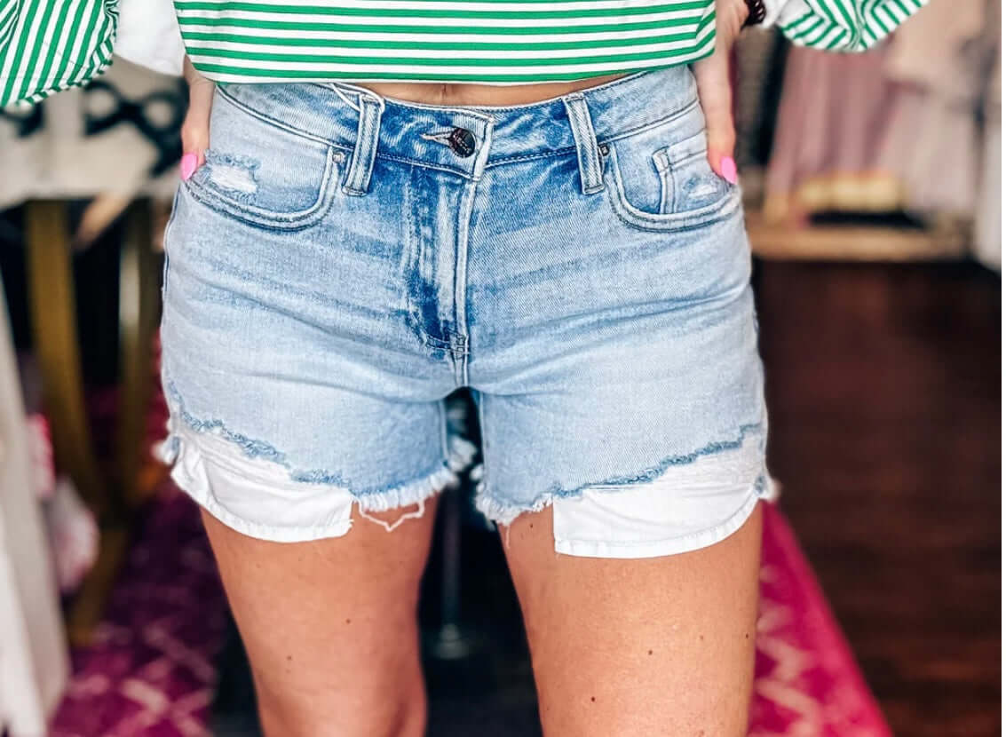 Risen High Rise Peek-a-Boo Lining denim shorts in light wash with trendy peek-a-boo detail.