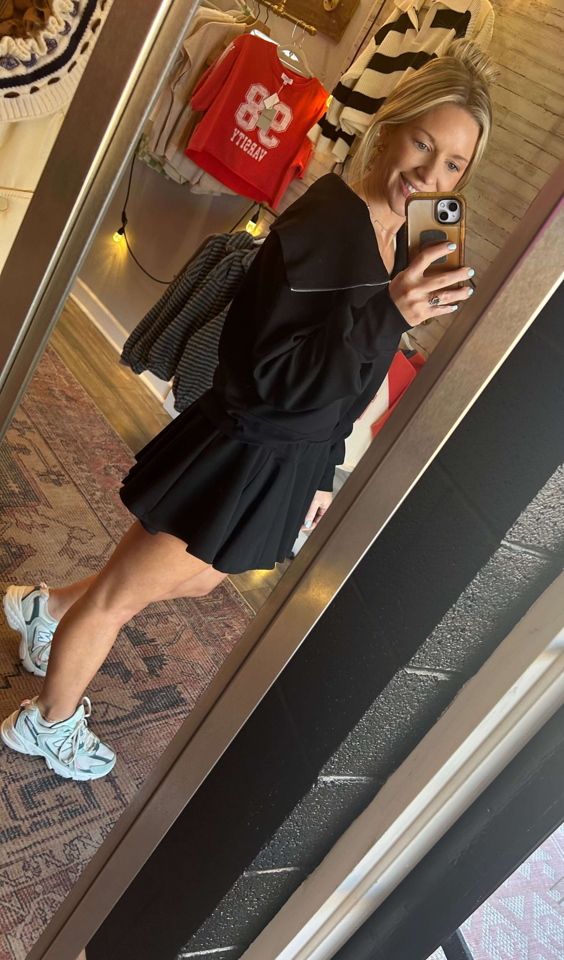 Neoprene flare skort and pullover set in black, featuring a cowl turtleneck and built-in shorts, stylishly displayed.