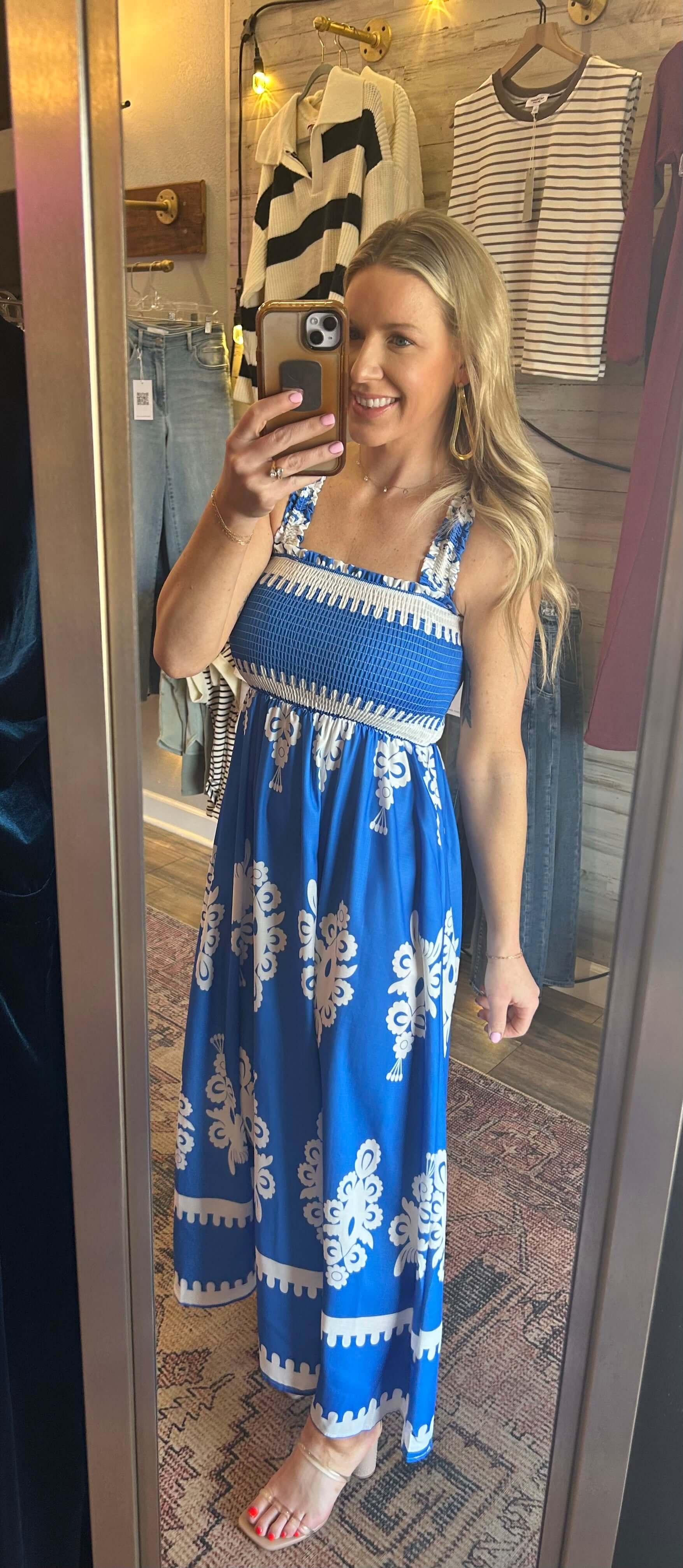 Woman wearing a smocked upper blue printed maxi dress with white patterns, perfect for summer events and vacations.